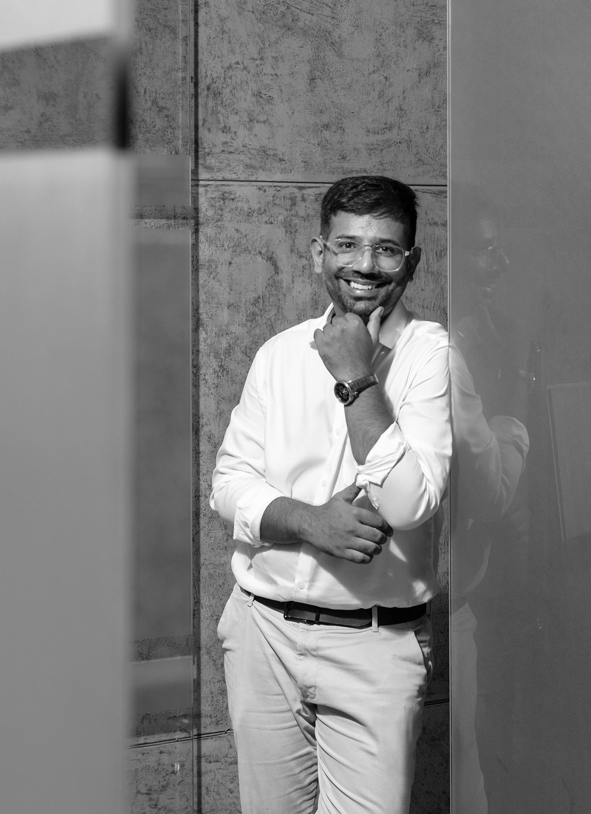 Black-and-white portrait of Mustafa Lokhandwala leaning against a wall